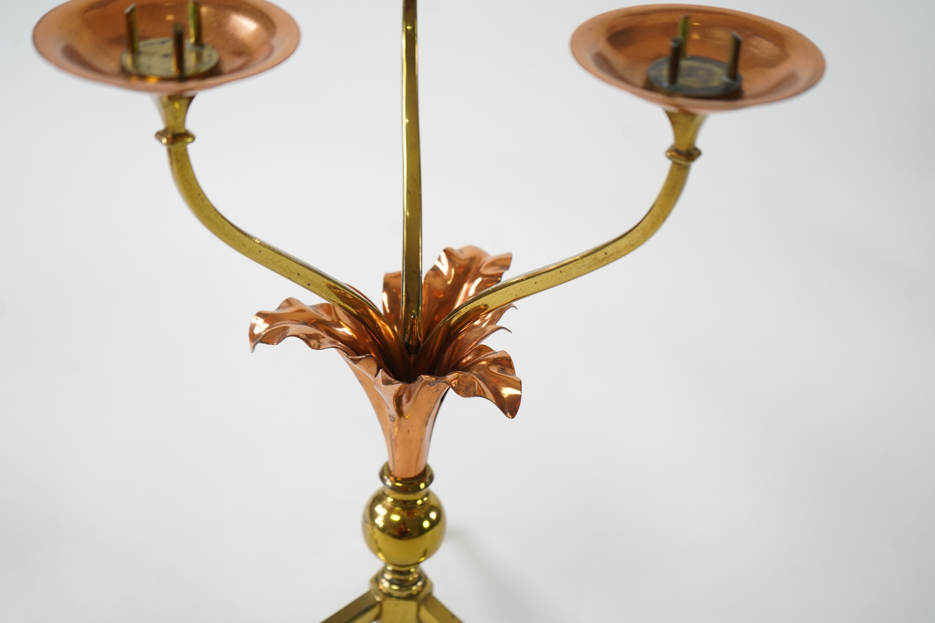 W.A.S. Benson & Co.: A pair of Arts and Crafts gilt brass and copper three branch candelabra